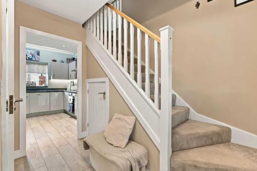 Hallway with a white staircase leading through to the kitchen