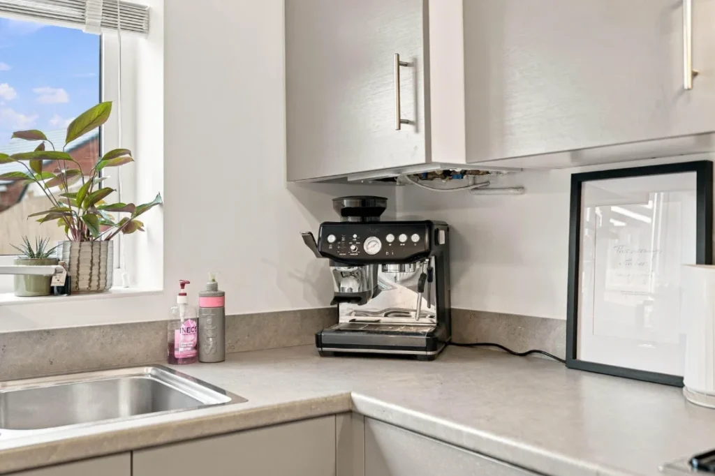 Kitchen corner with a coffee machine and a plant on the windowsill